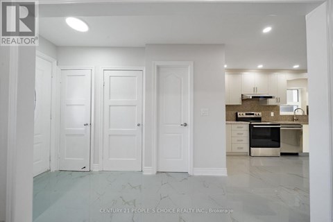 A kitchen with white cabinets and a marble floor.