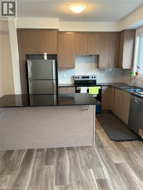 A kitchen with a refrigerator, stove, and oven.