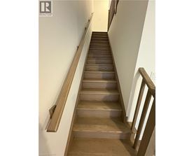 A long flight of wooden stairs with a handrail on the side.