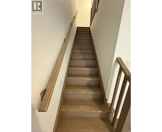 A long flight of wooden stairs with a handrail on the side.