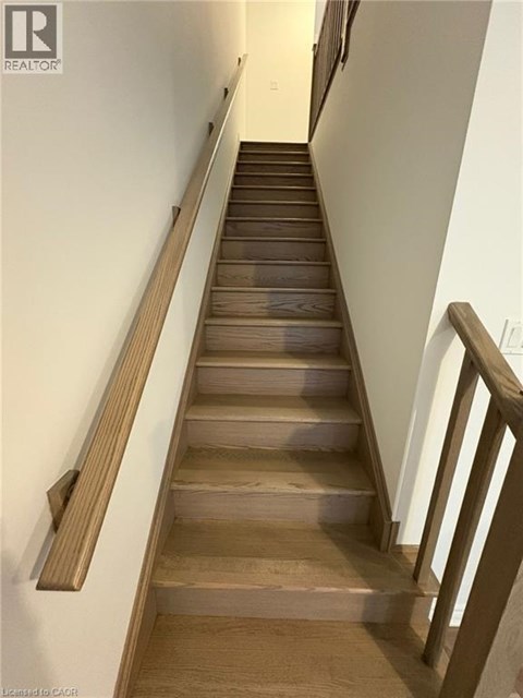 A long flight of wooden stairs with a handrail on the side.