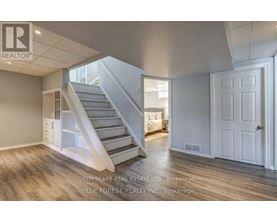A spacious room with a staircase leading to the upper level.