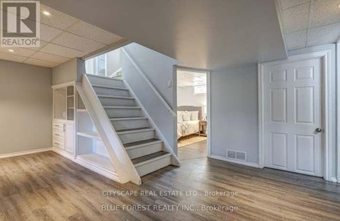 A spacious room with a staircase leading to the upper level.
