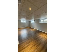 A room with wooden flooring and white walls.