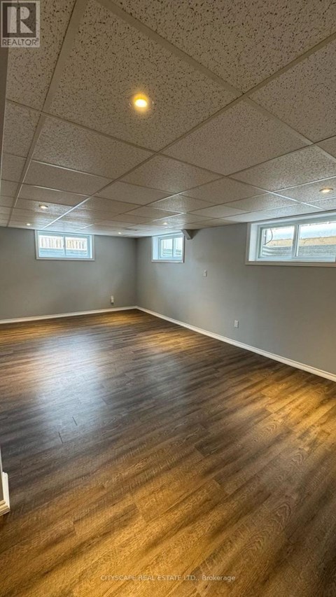 A room with wooden flooring and white walls.