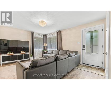A living room with a grey sofa and a glass door.