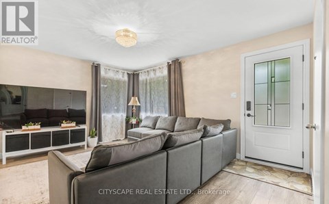 A living room with a grey sofa and a glass door.