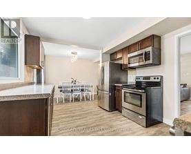 A kitchen with a dining table and chairs in the background.