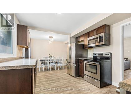 A kitchen with a dining table and chairs in the background.