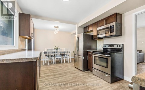 A kitchen with a dining table and chairs in the background.