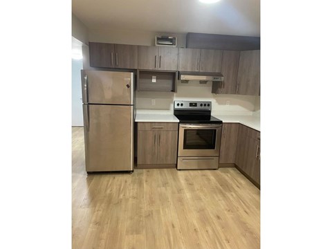 A kitchen with a stainless steel refrigerator and oven.
