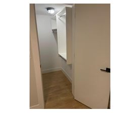 A white door is open to a hallway with a light on the ceiling.