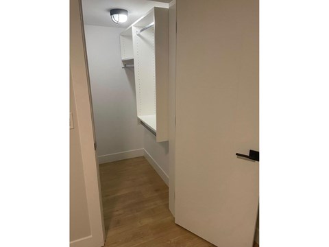 A white door is open to a hallway with a light on the ceiling.