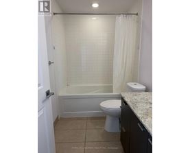 A white bathroom with a toilet, tub, and sink.