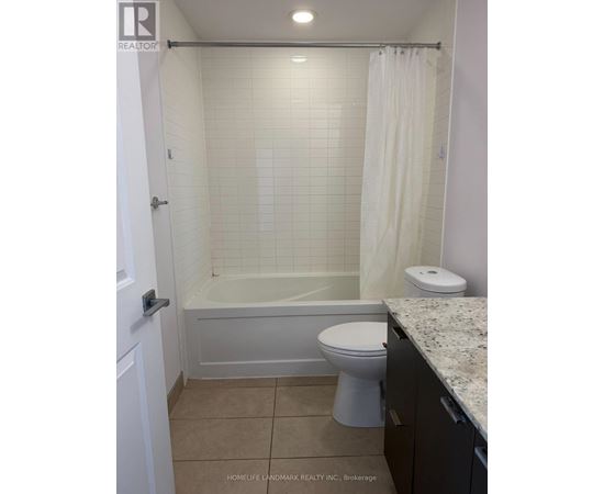 A white bathroom with a toilet, tub, and sink.