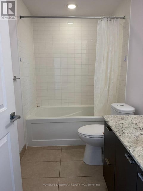 A white bathroom with a toilet, tub, and sink.