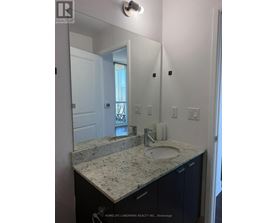 A bathroom with a granite countertop and a large mirror.