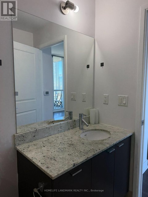 A bathroom with a granite countertop and a large mirror.