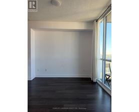 A room with a window and a wooden floor.