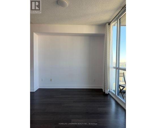 A room with a window and a wooden floor.
