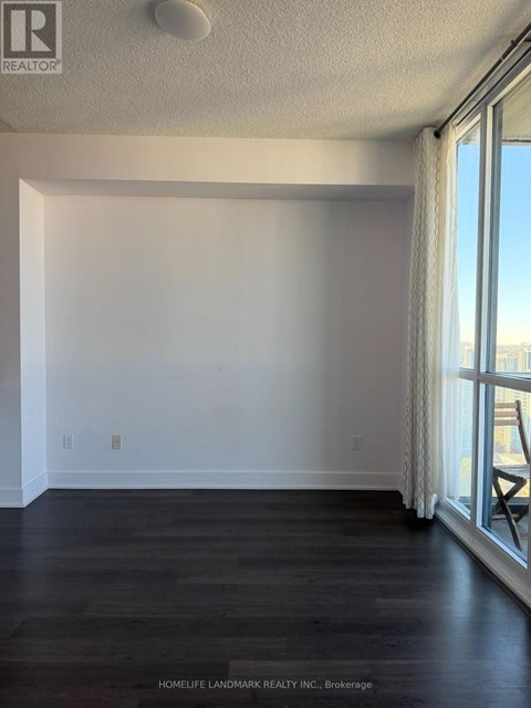 A room with a window and a wooden floor.