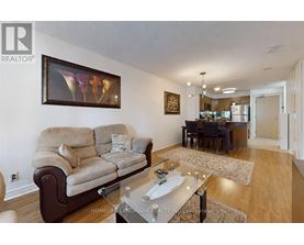A living room with a couch, a coffee table, and a painting on the wall.