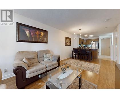 A living room with a couch, a coffee table, and a painting on the wall.