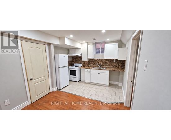 A kitchen with white appliances and cabinets.