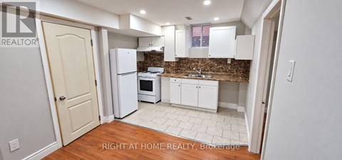A kitchen with white appliances and cabinets.