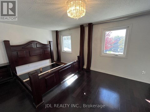 A bedroom with a large bed and a chandelier.