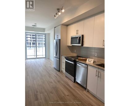 A kitchen with white cabinets and a wooden floor.