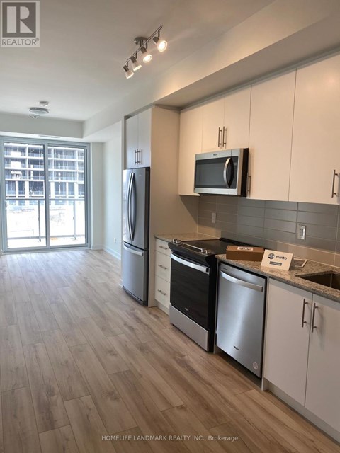 A kitchen with white cabinets and a wooden floor.