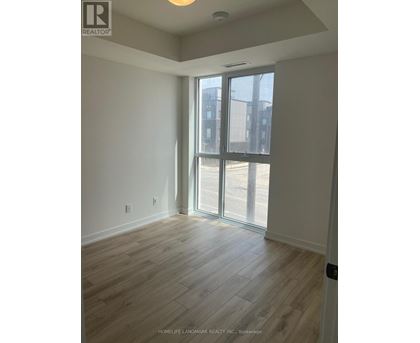 A room with a sliding glass door leading to a balcony.
