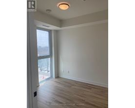 A room with a sliding glass door and wood flooring.