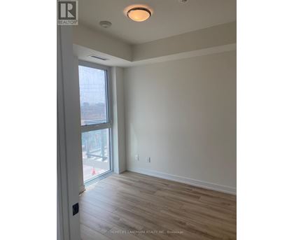 A room with a sliding glass door and wood flooring.
