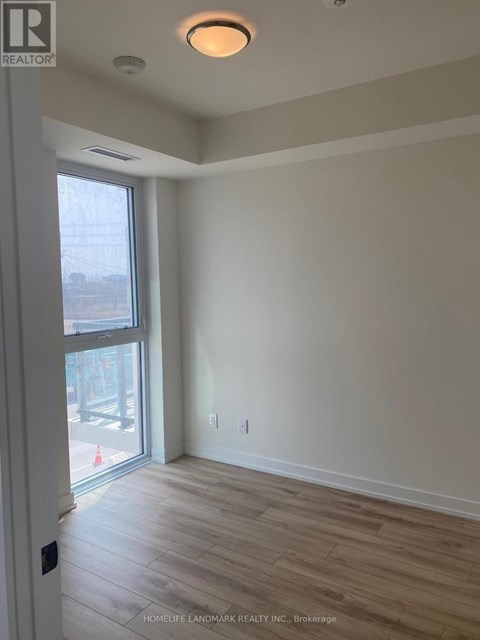 A room with a sliding glass door and wood flooring.