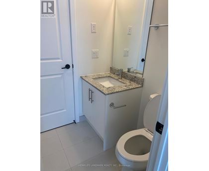 A white bathroom with a toilet, sink, and mirror.