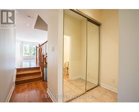 A hallway with a glass door leading to a bedroom.