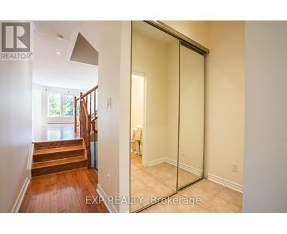 A hallway with a glass door leading to a bedroom.