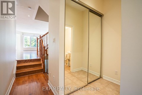 A hallway with a glass door leading to a bedroom.