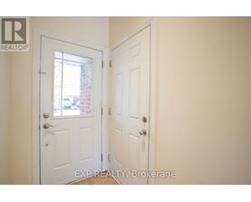 A white door with a glass window is in a room with a white wall.