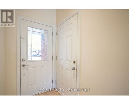 A white door with a glass window is in a room with a white wall.