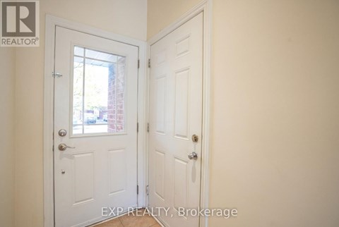 A white door with a glass window is in a room with a white wall.