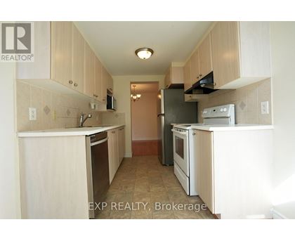 A kitchen with white cabinets and appliances.