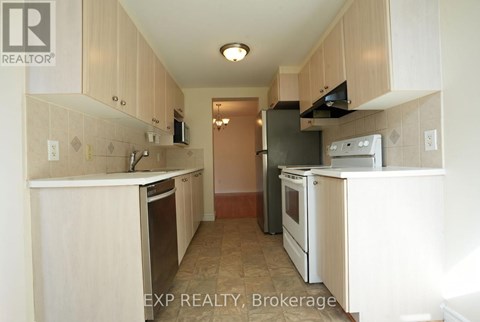 A kitchen with white cabinets and appliances.
