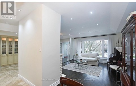 A living room with a white couch and a piano.
