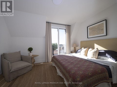 A bedroom with a large bed and a couch.