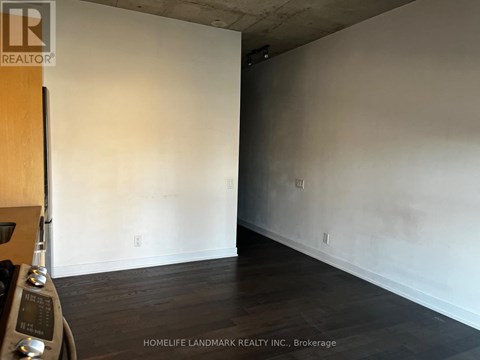 A room with wooden floors and white walls, with a logo for HomeLife Landmark Realty Inc. in Brokerage.