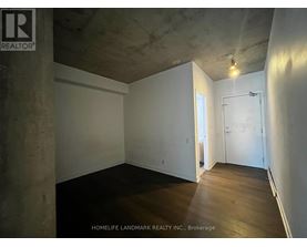 A room with a concrete pillar and wooden flooring.