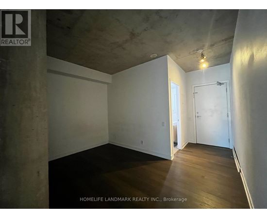 A room with a concrete pillar and wooden flooring.